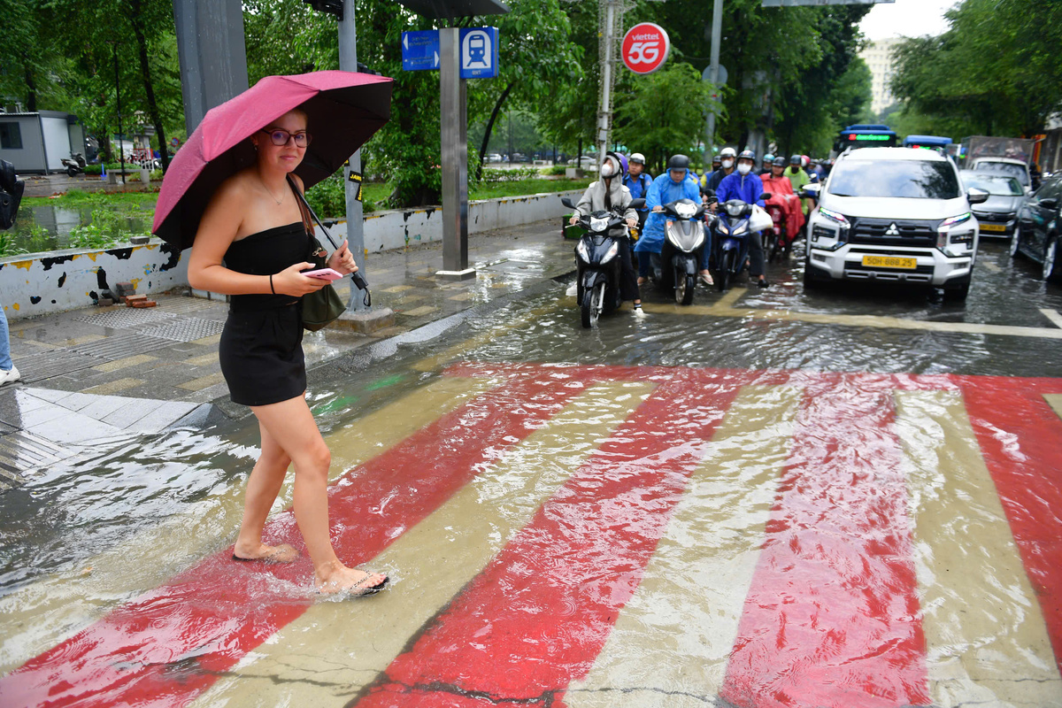 Tourists wade through flooded HCMC streets as heavy rain hits