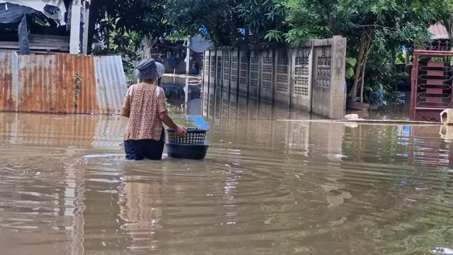 Thailand Braces for New Rains Amid Flood Fears in Chainat; Elderly Woman Navigates 80cm Water by Boat